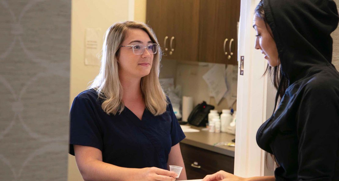 Two women engage in a meaningful conversation about the multiple drug and alcohol intervention methods, including the Johnson Model, Invitational Model, Systemic Family Model, ARISE Model, Motivational Interviewing, CRAFT, and the Field Model, showcasing their special approaches to wellness.