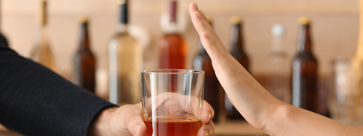 Hand refusing a drink in bar